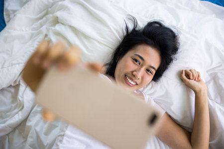 close up of happy mother and her son Taking pictures or selfie or video call or relatives in a bed. Concept of new generation, family, parenthood, authenticity, connectionの写真素材