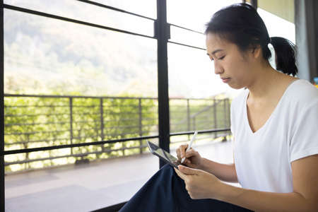 woman sitting with using tablet in a bed at home. The use of concept of new generation, family,...