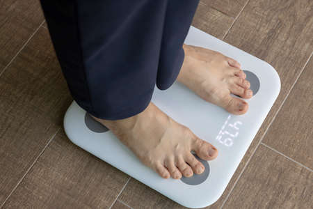 Close-up woman of weigh in living room. Concept of technology, connection, communication.の写真素材