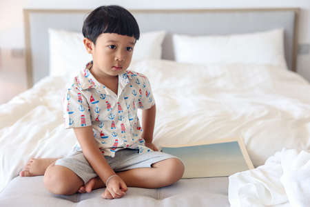 Close up. Portrait a Asian boy with bangs hair cheerful is so adorable child, wearing white shirt, Active 4-5 years old kid smiling funny shocked face and looking at camera.の写真素材