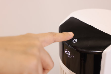 Close-up Asian woman hand, pressing a button on air purifier machine in a bedroom. Protect PM 2.5...