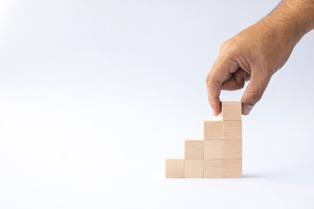 hand arranged stacked wooden cubes as steps on white background. concept about education, business, play, strategy, and success.の写真素材