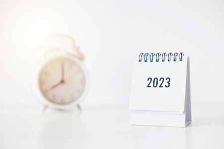 2023 business calendar and alarm clock on office table in new year day. Make a work plan for the start of the year. Concept about Celebration, Business, Christmas, New Year.の写真素材