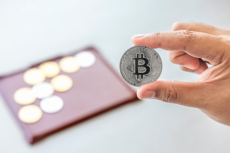 Close-up hand of man holding crypto coin on coin tray background. Blockchain technology finance in future. Male hold bitcoin. concept about business, finance, trade, economy, banking, investment.の写真素材