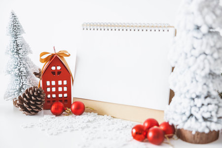 The White calendar mock up to enter text by the festive scene of beautiful Christmas tree adorned, with Christmas balls, pine cones, red house gift box tied golden ribbon. concept about Important day.の写真素材