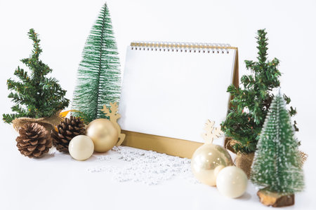 The White calendar mock up to enter text by the festive scene of beautiful Christmas tree adorned, with Christmas balls, pine cones, red house gift box tied golden ribbon. concept about Important day.の写真素材