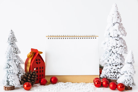 The White calendar mock up to enter text by the festive scene of beautiful Christmas tree adorned, with Christmas balls, pine cones, red house gift box tied golden ribbon. concept about Important day.の写真素材