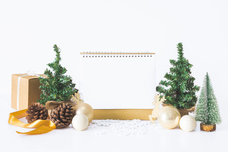 Calendar with white background to add desired message or image for New Year's event or important day along with Christmas tree scene, gift box, Christmas ball, pine cone. Concept of important day.の写真素材