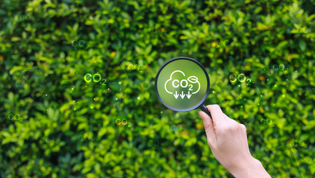 Hand holding magnifying glass with icons for co2, ESG and net zero. energy saving concept. save our planet, world environment day, world earth day. sustainable development and green business.の写真素材