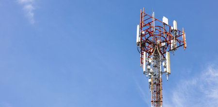Telecommunication tower against blue sky with digital wireless network and futuristic technology...
