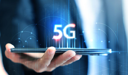 Hand holding smartphone with 5G icon and global network interface, representing high-speed wireless...