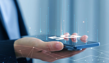 Hand holding smartphone with 5G icon and global network interface, representing high-speed wireless technology, digital connectivity, IoT, and future communication concept. communication network.の写真素材