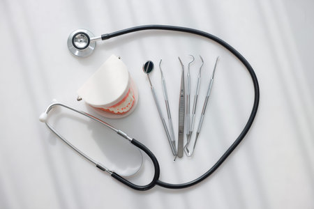 Top view dental tools, tooth model and stethoscope on white background. Concept of oral health care,...