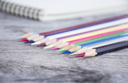 closeup color pencils and blur note on  wooden backgroundの写真素材