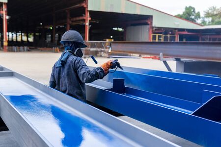 The painter is working to painting color top coat on steel structure with spray gun, at industrial factory.の写真素材