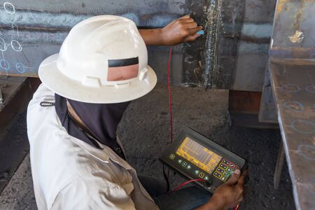 The inspectors are checking defect in welded of steel add joint with process Ultrasonic testing (UT) of Non-Destructive Testing(NDT) at industrial factory.の写真素材