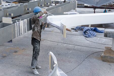The painter is working to fireproof paint on steel structure with spray gun, at industrial factory.の写真素材