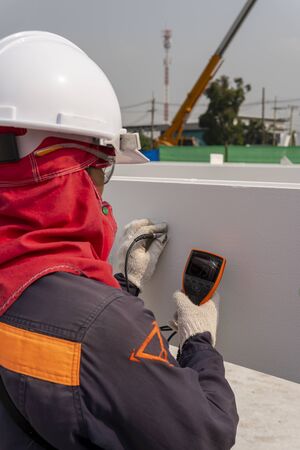 Technicians are measuring the Dry Film Thickness (DFT) with Coating Thickness Gauge for painting of steel structure work in industrial factory. の写真素材