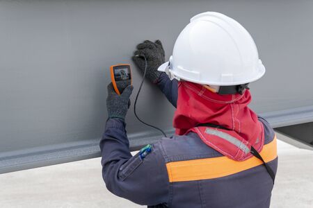 Technicians are measuring the Dry Film Thickness (DFT) with Coating Thickness Gauge for painting of steel structure work in industrial factory. の写真素材
