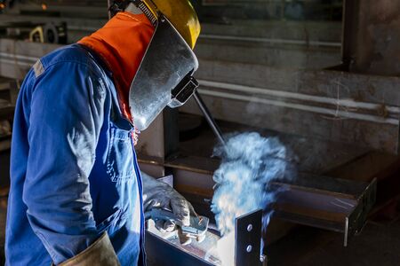 The welder is welding a steel structure work with process Flux Cored Arc Welding(FCAW) and dressed...