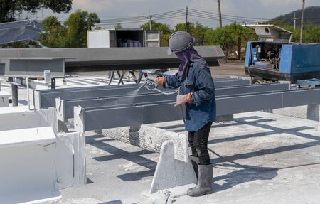The painter is working to painting color top coat on steel structure with spray gun, at industrial factory.の写真素材