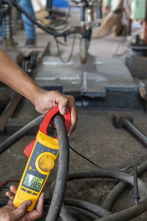 Measure amps while welding with digital clamp meter in process pre-qualification record(PQR).の写真素材