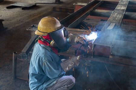 The welder is welding a steel structure work with process Flux Cored Arc Welding(FCAW) and dressed...