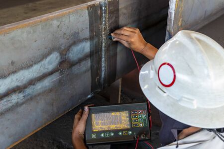 The inspectors are checking defect in welded of steel add joint with process Ultrasonic testing (UT) of Non-Destructive Testing(NDT) at industrial factory.の写真素材