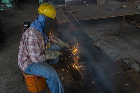 The welder is welding a steel structure work with process Flux Cored Arc Welding(FCAW) and dressed...