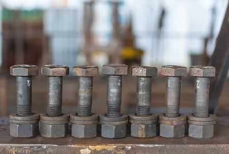 Seven bolt, nut and washer placed on a steel plate.blurred backgroundの写真素材