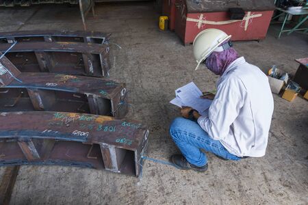 Technicians are recording the measured value from the steel structure. In the final inspection of the workpiece before delivery to paint. at industrial factory.の写真素材