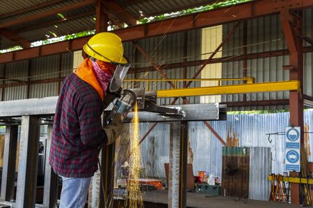 Men is used Grinding Machine to Grinding welded on steel structure, at Industrial factory.