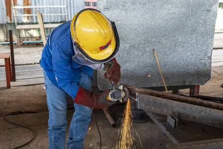 Worker is used Grinding Machine to grinding surface of H-Beam steel after cutting, at Industrial factory.の写真素材