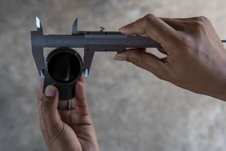 Using Vernier caliper to measure the dimensions outside diameter of the Elbow Pipe Fittings.の写真素材