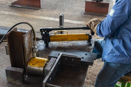Workers are using hydraulic jacks. bending steel plate in industrial factory.の写真素材