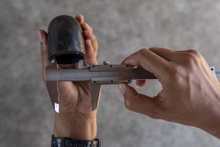 Using Vernier caliper to measure the dimensions inside diameter of the Elbow Pipe Fittings.の写真素材