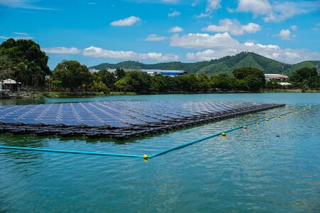Floating Solar Farm or Solar panels on  the river with blue sky and mountain is the background.