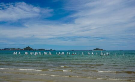 Sailboat in the sea with blue sky and white clouds