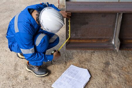 Technicians are using measuring tape to checking the accuracy of the steel structureの写真素材