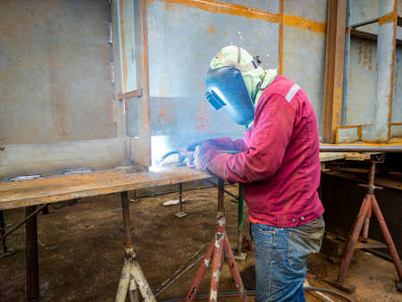 The welder is welding a steel structure work with process Flux Cored Arc Welding(FCAW) and dressed...
