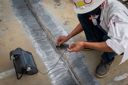 The inspectors are checking defect in welded of steel plate add joint with process Ultrasonic...