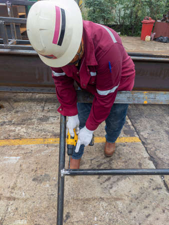 Workers are using a Drill Machine to drill holes in the handrails before hot-dip galvanizing, to...