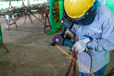 Welder is used Grinding machine to grinding remove tack weld on steel pipe before welding at...