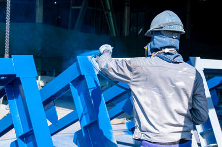 The painter uses a spray gun to paint a steel structure before transportation to the assembly yard.の写真素材