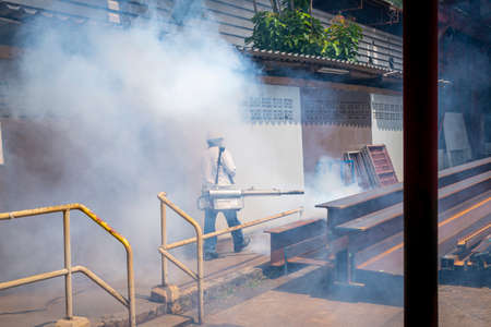 Men are using a fogging machine to get rid of mosquitoes and insects in industrial factories.