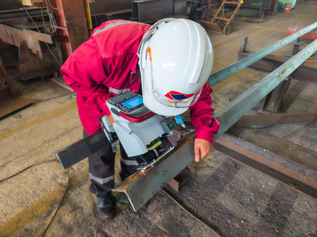 A worker is Stamping a Number on a Steel Structure Piece with a Mobile dot peen marker.の写真素材