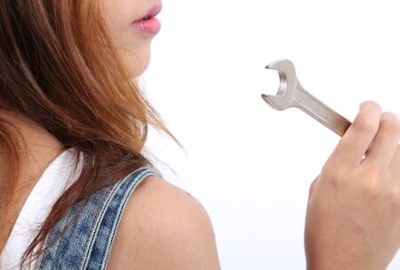Image of woman worker holding stainless steel wrench for her jobの写真素材