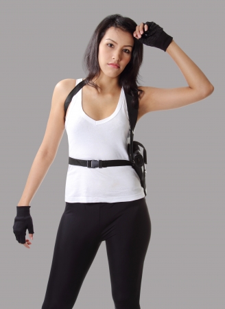 asian woman wearing white vest with her handgunの写真素材