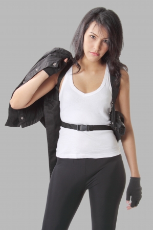 asian woman wearing white vest with her handgunの写真素材