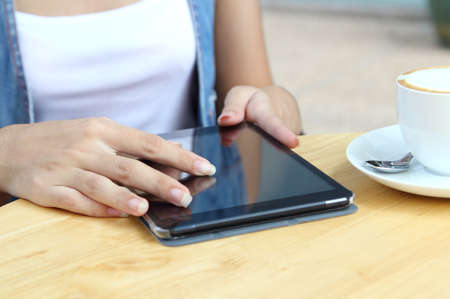 asian woman working touch her tablet and search information at coffee shopの写真素材